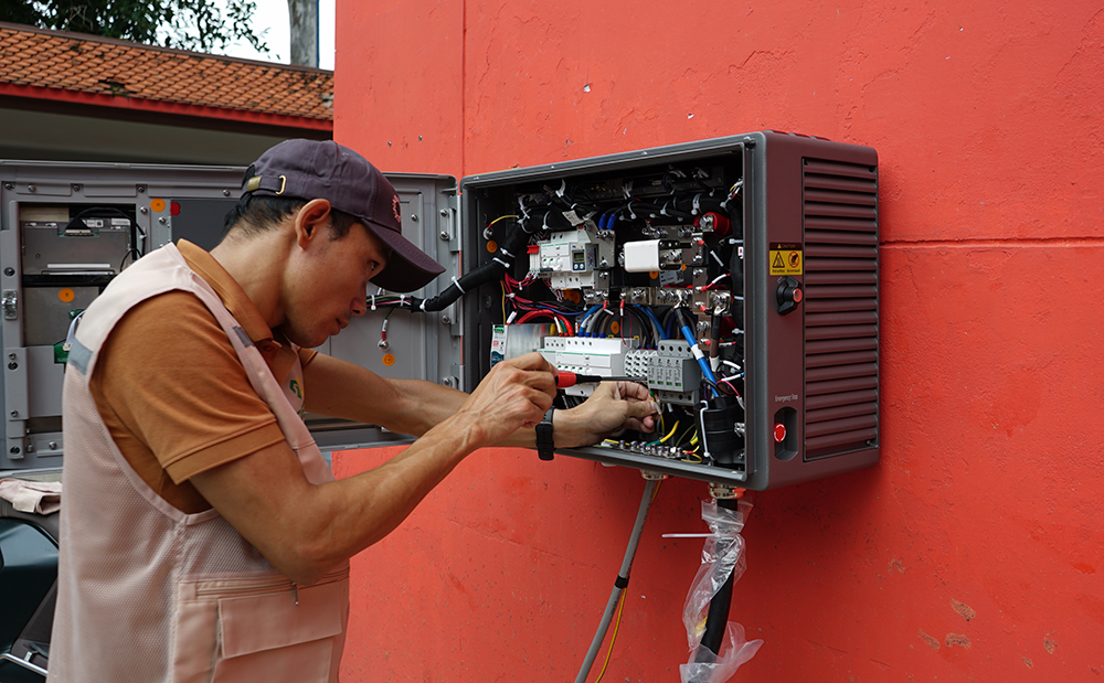 Kỹ sư đang thi công lắp đặt một bộ sạc treo tường tại Hà Nội. Ảnh: Lê Vũ.