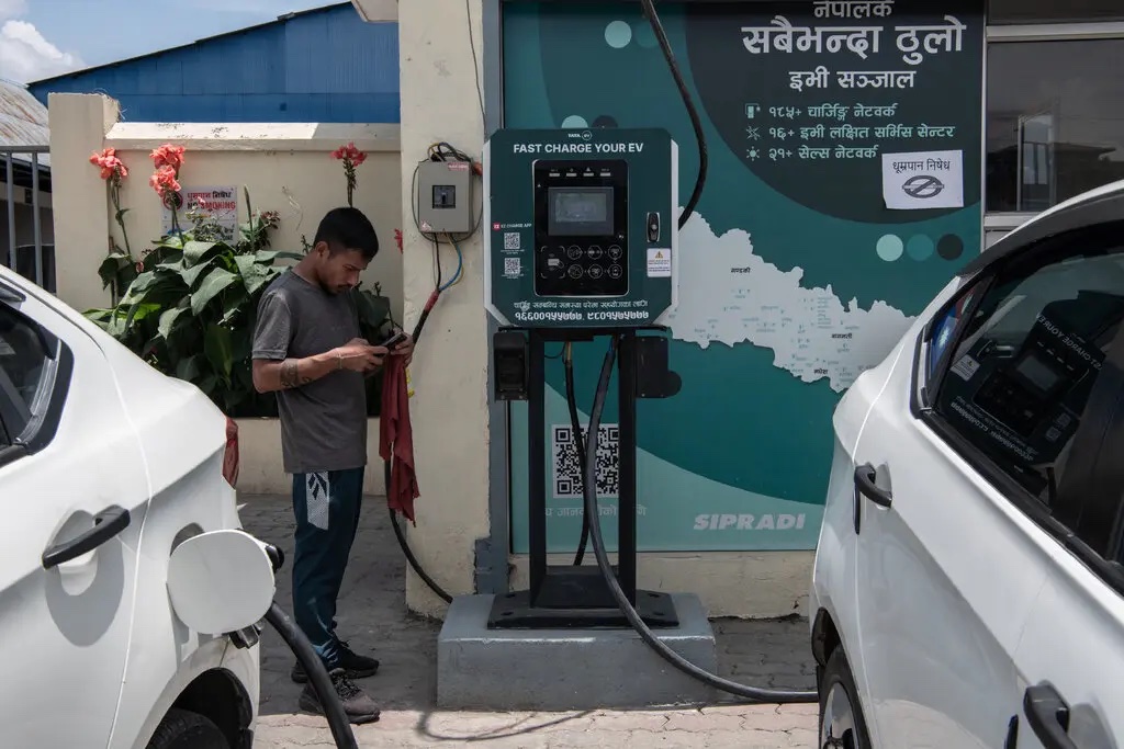 Nhiều xe taxi ở Kathmandu đã chuyển sang dùng điện. Tài xế tranh thủ thời gian sạc pin để vệ sinh xe và thư giãn. Ảnh: NYT.