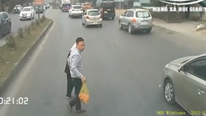 Tài xế container "sống chậm" dừng xe để dắt cụ bà qua đường