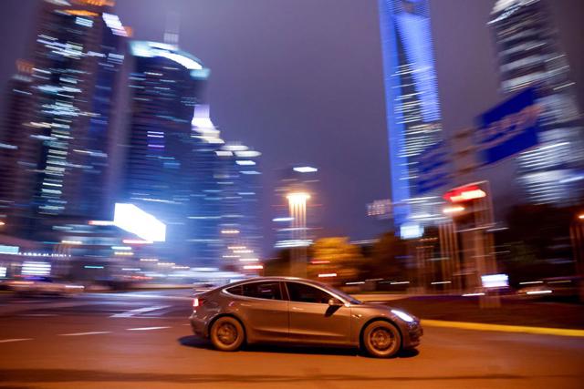 Một chiếc xe điện Tesla l&aacute;i qua một ng&atilde; tư ở Thượng Hải, Trung Quốc.