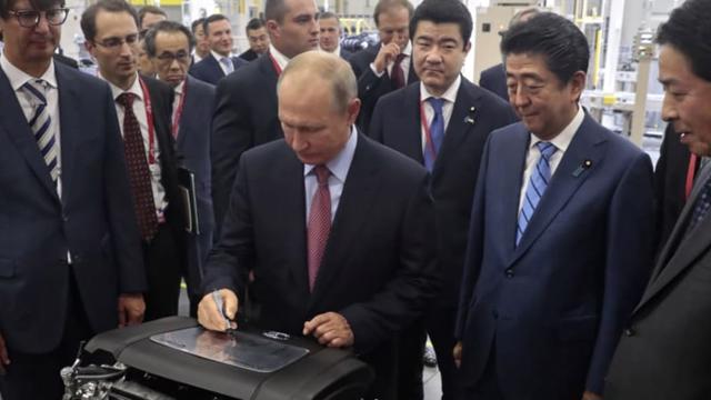 Tổng thống Nga Vladimir Putin k&yacute; tr&ecirc;n một động cơ v&agrave;o năm 2018 trong khi thăm nh&agrave; m&aacute;y &ocirc; t&ocirc; Mazda Sollers Manufacturing Rus với cố Thủ tướng Nhật Bản Shinzo Abe ở Vladivostok, Nga. Ảnh: AP.