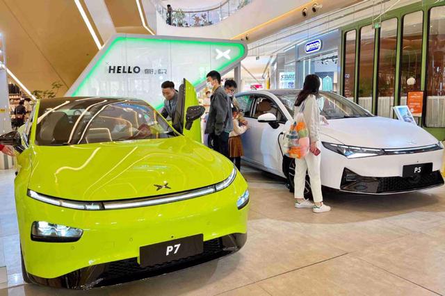Du kh&aacute;ch kiểm tra c&aacute;c mẫu xe của Xpeng trong một trung t&acirc;m mua sắm ở Bắc Kinh. Ảnh:&nbsp;China Daily.