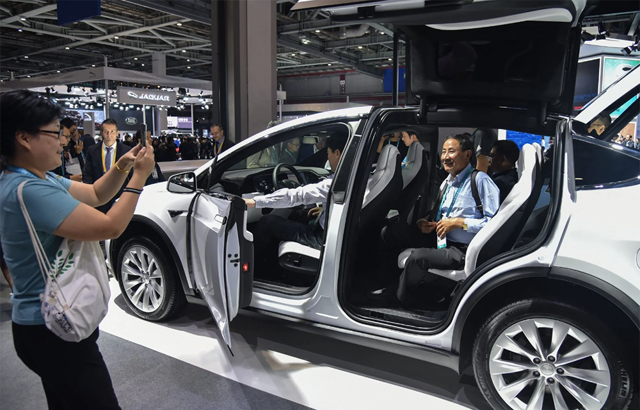 Người d&acirc;n Trung Quốc xem một chiếc xe Tesla tại Thượng Hải v&agrave;o th&aacute;ng 11 năm 2019. Ảnh: AFP.