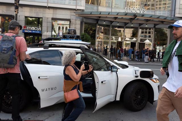 Khách hàng bước vào xe taxi không người lái Waymo ở San Francisco, California, Mỹ. Ảnh: Reuters.