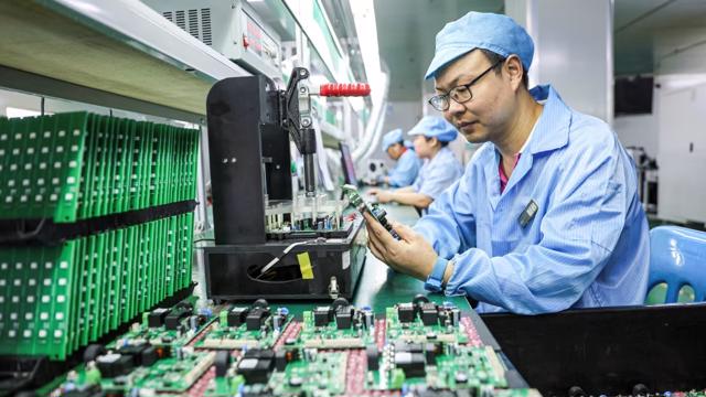Nh&acirc;n vi&ecirc;n l&agrave;m việc tr&ecirc;n d&acirc;y chuyền sản xuất trạm sạc &ocirc; t&ocirc; điện tại một nh&agrave; m&aacute;y ở tỉnh Giang T&acirc;y, miền trung Trung Quốc. Ảnh: Getty Images. &nbsp;