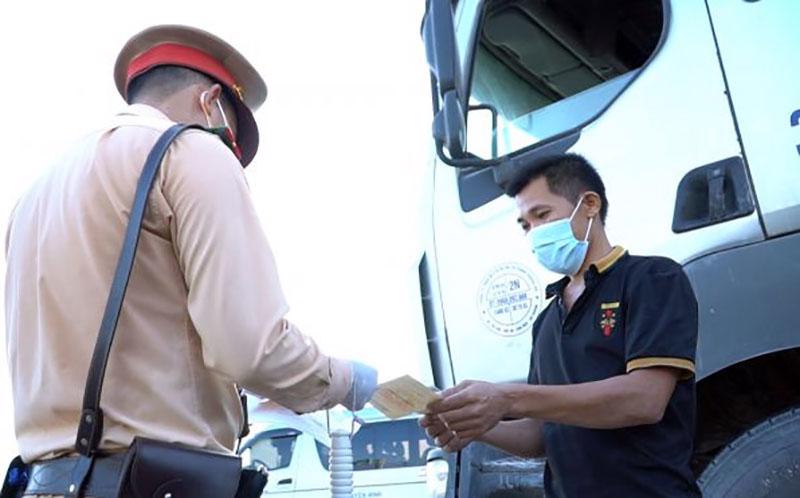 CSGT kiểm tra giấy tờ xe và giấy xét nghiệm Covid-19 của tài xế. Nguồn ảnh: Cục CSGT.