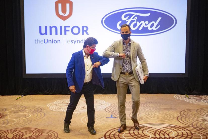 Chủ tịch Unifor Jerry Dias, trái, chạm khuỷu tay vào Ryan Kantautas, Phó Chủ tịch Nhân sự của Ford Canada, trước khi đàm phán hợp đồng chính thức với Fiat Chrysler.
