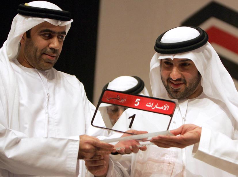 Doanh nhân Saeed Khoury (phải) tạo dáng với chiếc biển số xe hơi đắt nhất sau khi anh giành được nó trong một cuộc đấu giá ở Abu Dhabi vào ngày 16 tháng 2 năm 2008. AFP.