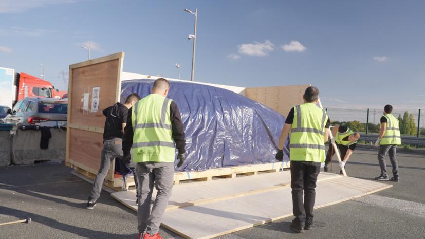 Các công nhân đang vận chuyển các mẫu xe của Vinfast vào trong triển lãm.