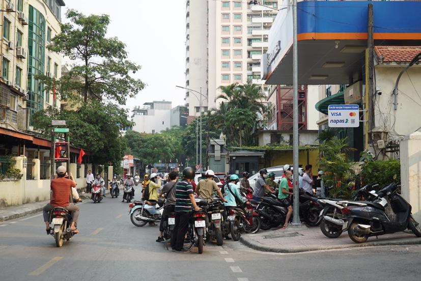 Các phương tiện dừng, đỗ dưới lòng đường để xếp hàng mua xăng, gây cản trở giao thông.