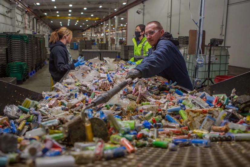 Heath Millim, một nhân viên của Redwood, xúc những viên pin bị vứt bỏ trong khi hai nhân viên khác phân loại các loại pin trong nhà máy của Redwood ở Carson City.