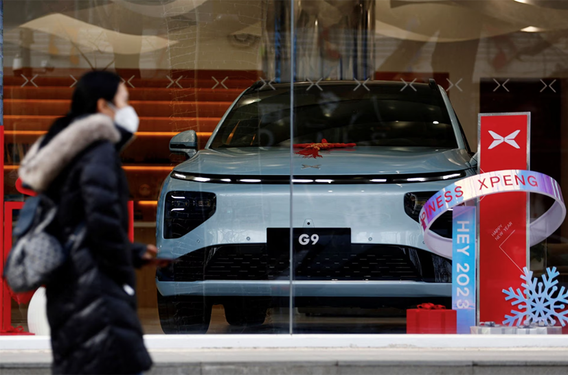 Một người đi ngang qua xe điện XPeng G9 (EV) tại cửa hàng hàng đầu của hãng ở Bắc Kinh, Trung Quốc ngày 2 tháng 2 năm 2023. Ảnh: REUTERS.
