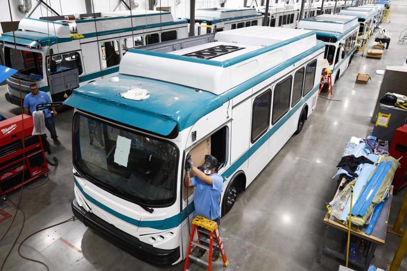 Một nhân viên làm việc trên khung cửa sổ của một chiếc xe buýt điện tại nhà máy BYD Coach and Bus ở Lancaster, California. Ảnh: Bloomberg.