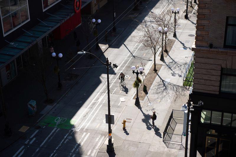 Một người đạp xe trên một con đường vắng hoe ở thành phố Seattle, Mỹ - Ảnh: Bloomberg.