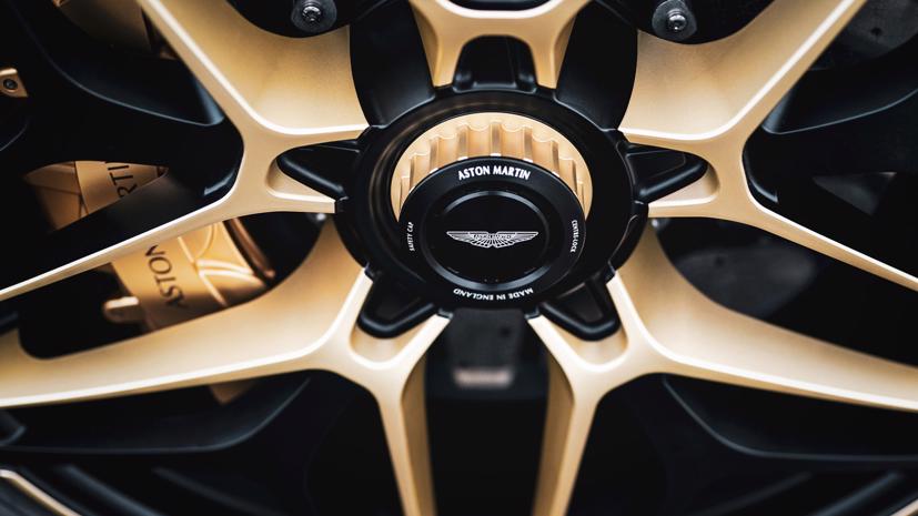 Bên trong là đĩa phanh cỡ lớn và càng phanh sơn vàng nổi bật. Giữa lazăng là logo Aston Martin. Ảnh: AutoBlog.