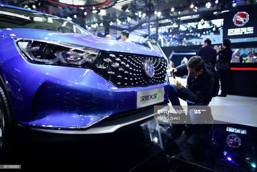 Một người đàn ông đang chụp ảnh mẫu xe điện Hanteng X5EV tại Triển lãm ô tô Bắc Kinh ngày 26/4/2018. Ảnh: Getty Image