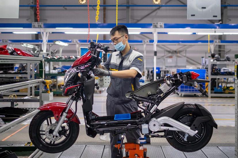 Một kỹ sư VinFast đang lắp ráp xe máy điện. Ảnh: Bloomberg