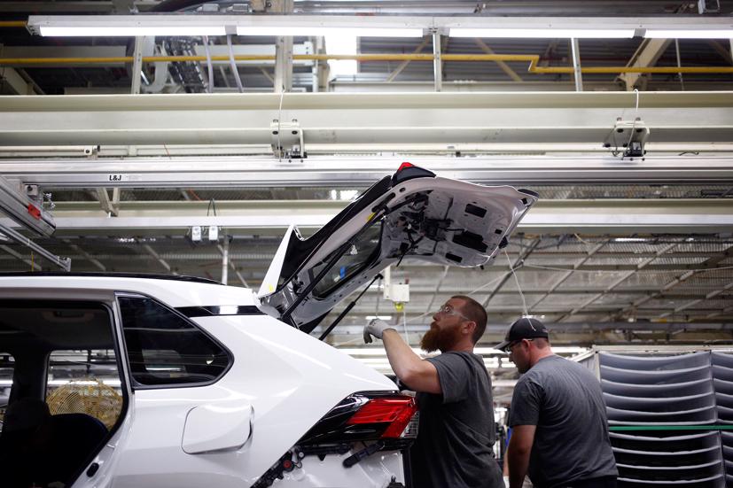 Một công nhân nhà máy đang cài đặt các bộ phận trên RAV4 hybrid. Ảnh: Bloomberg