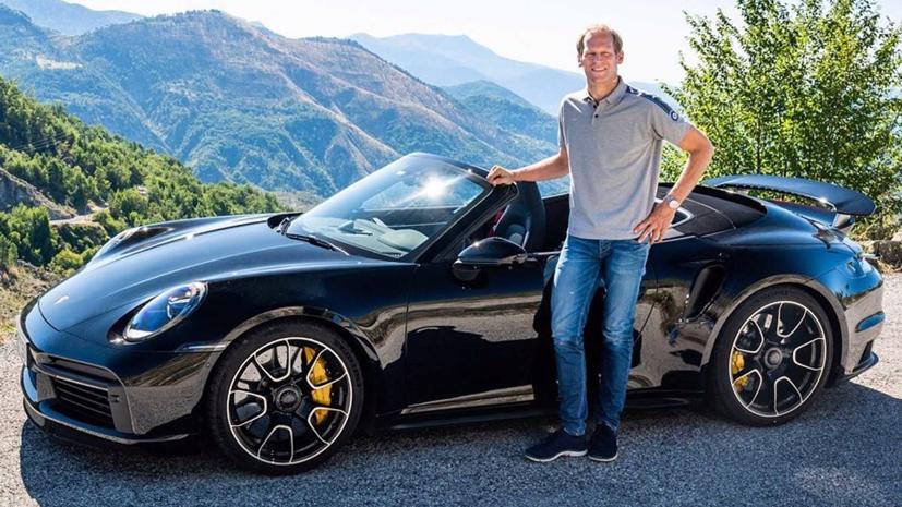 Tay đua Joerg Bergmeister bên cạnh một chiếc 911 Turbo Cabriolet.